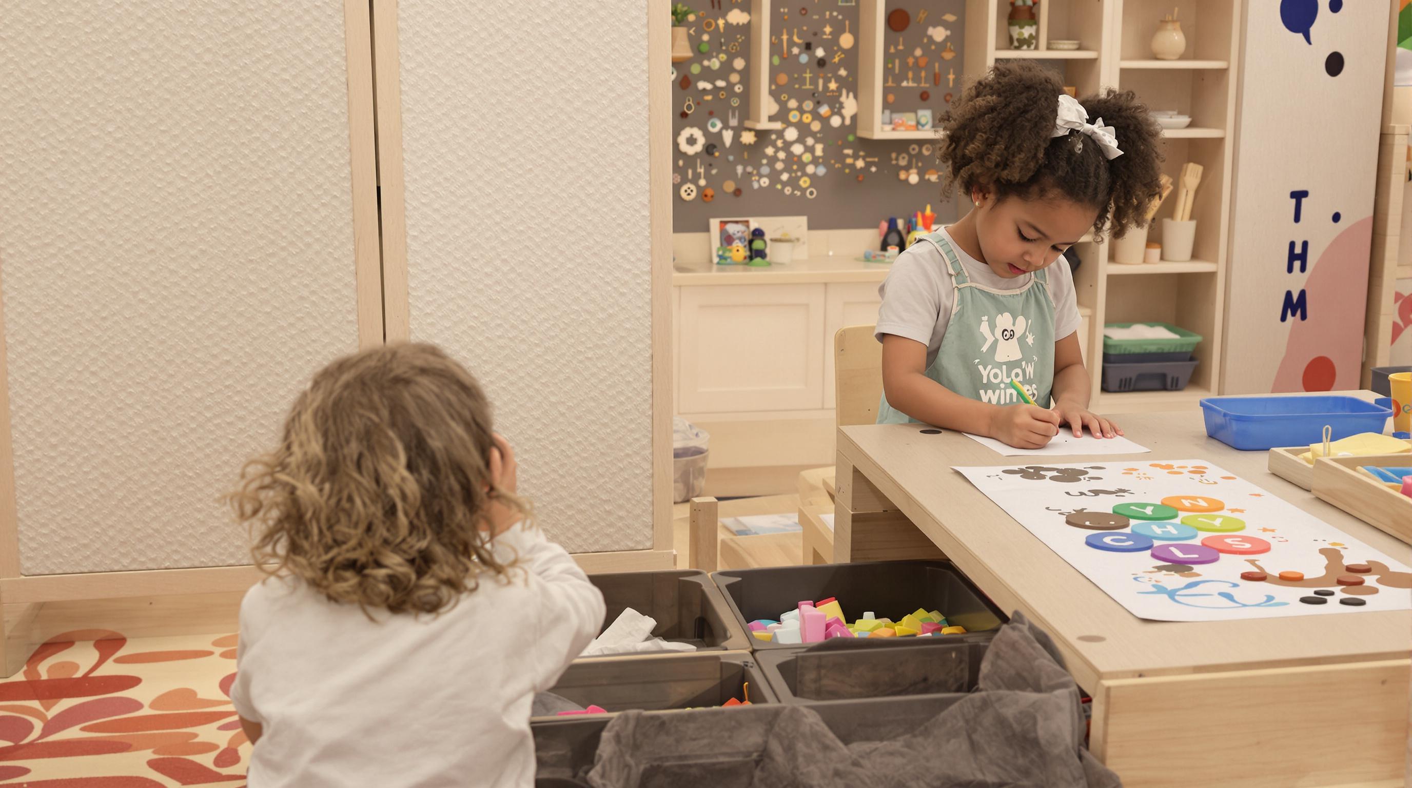Children using a sensory game table with textured elements and art surfaces for creative play