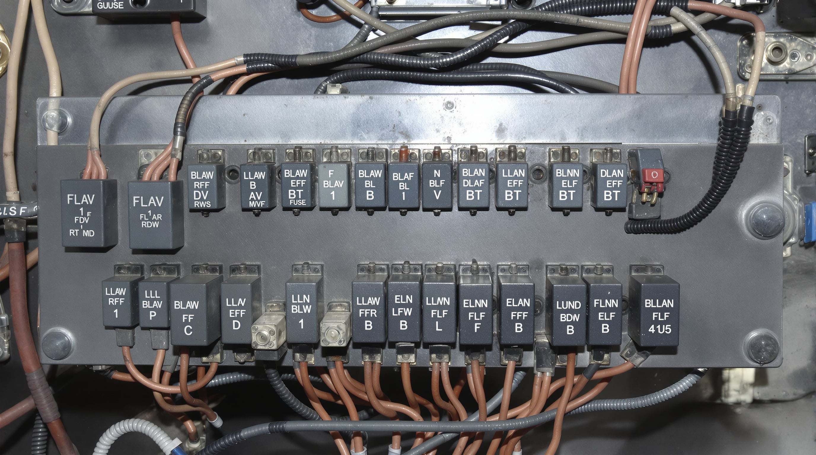 Close-up of a truck switch panel displaying relays, fuses, and copper terminals