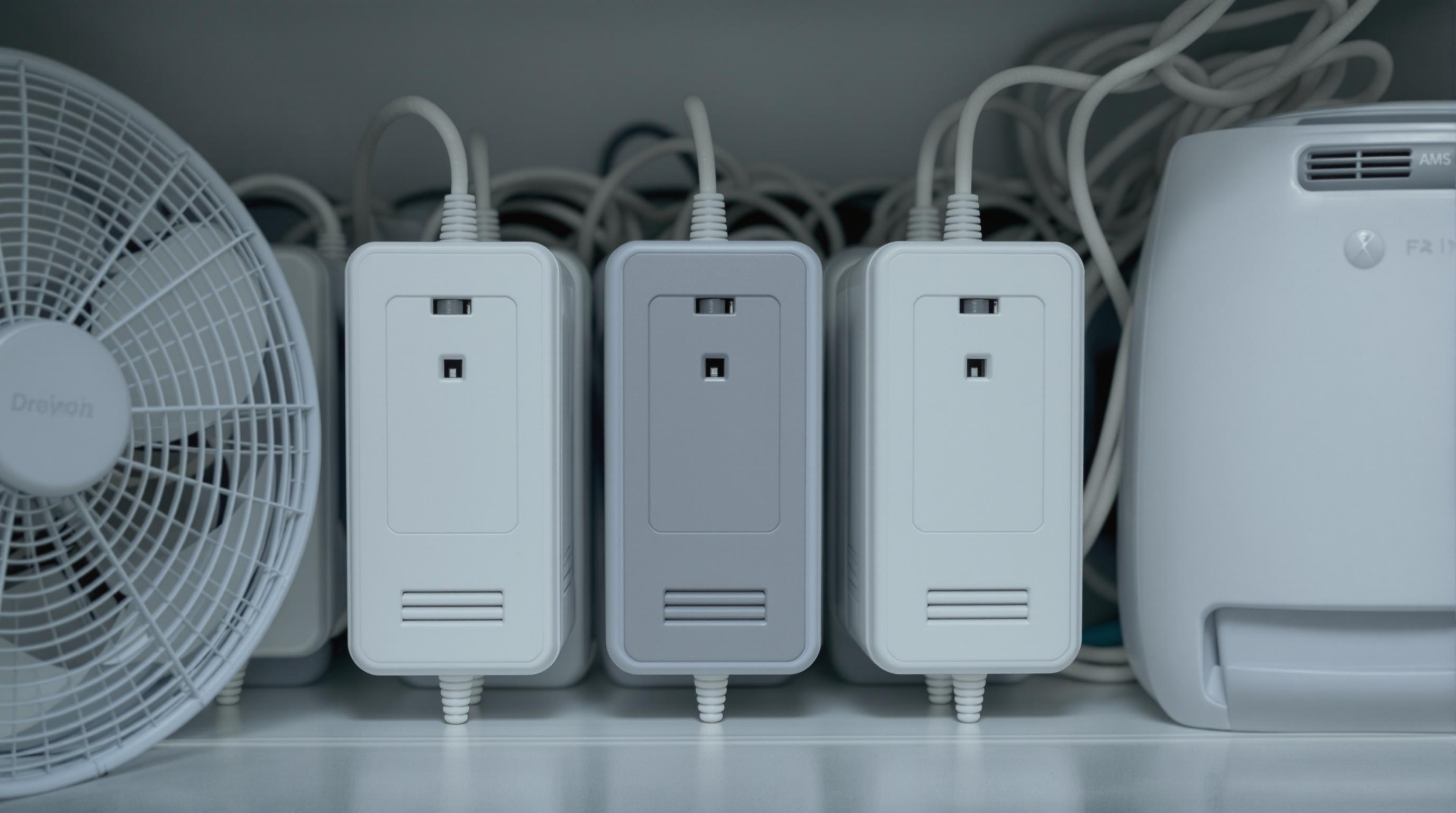 AC adapters positioned with clear spacing for ventilation, visible vents, cooling fan and dehumidifier present