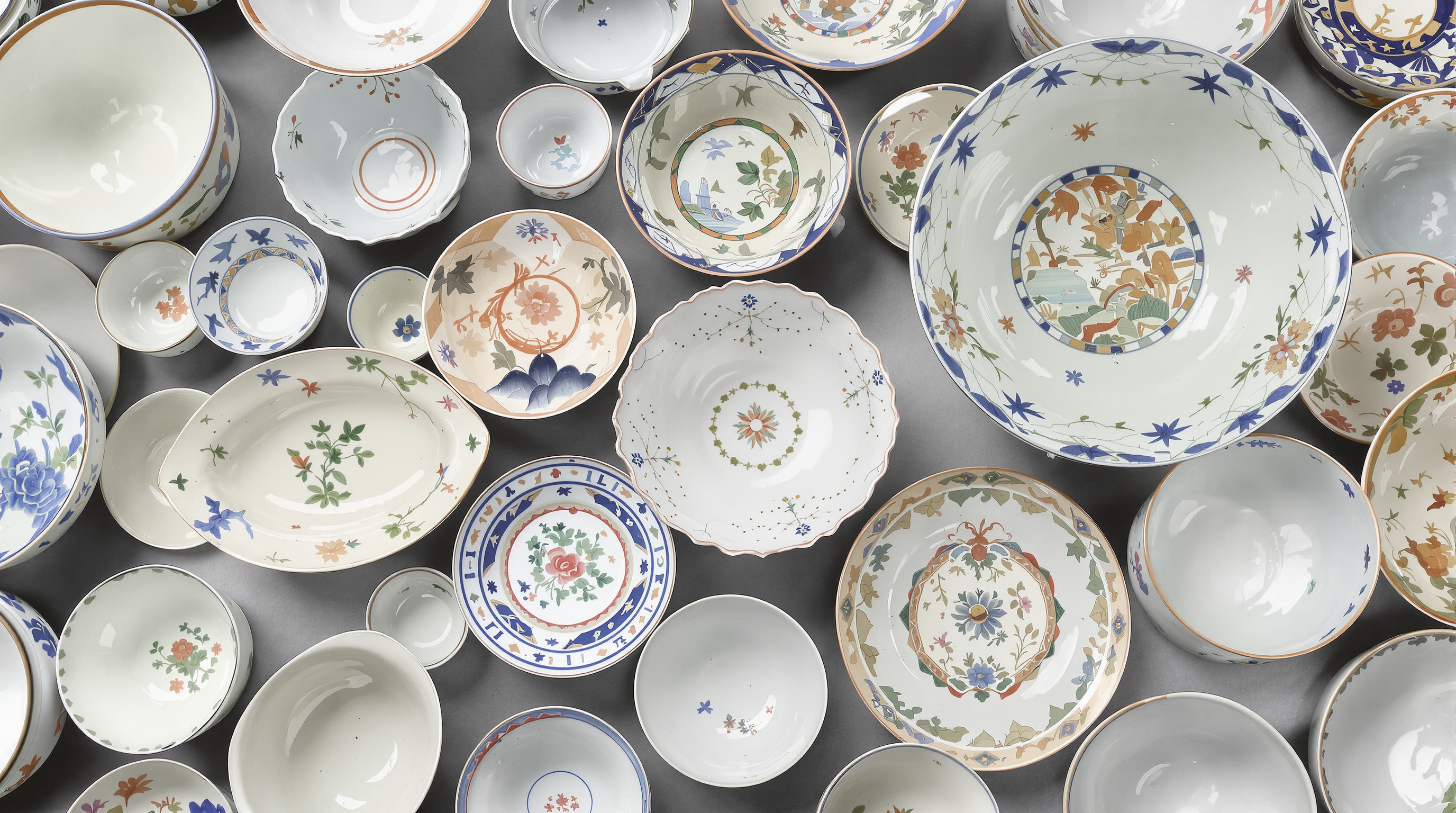 Assorted porcelain bowls of different sizes and shapes shown from above