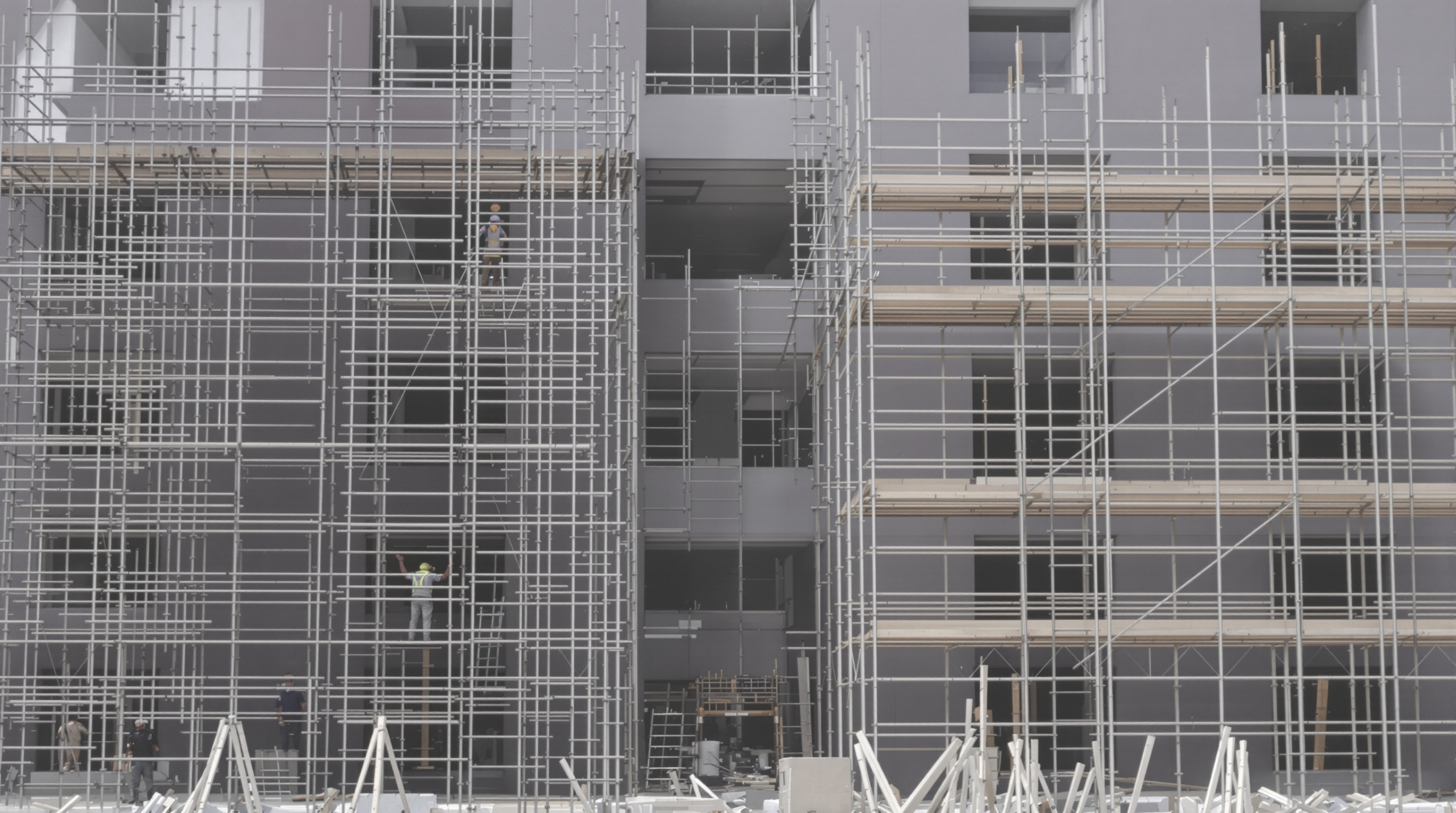 Side-by-side comparison of frame and traditional tubular scaffolding systems being assembled on a residential jobsite