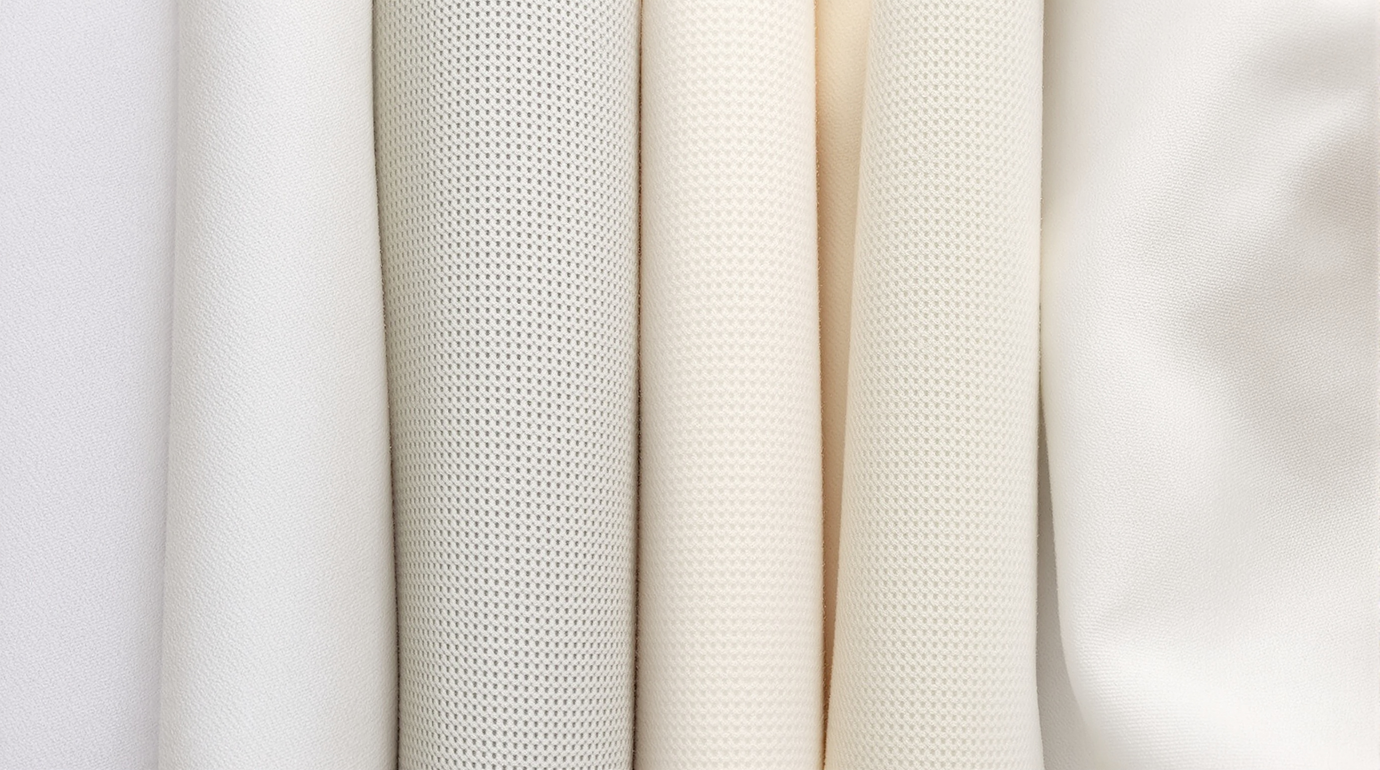 Macro close-up of various hypoallergenic fabric swatches showing tight weaves and soft textures