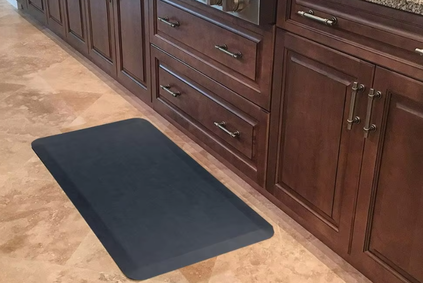 Why is non-slip backing crucial for kitchen mats near sinks?
