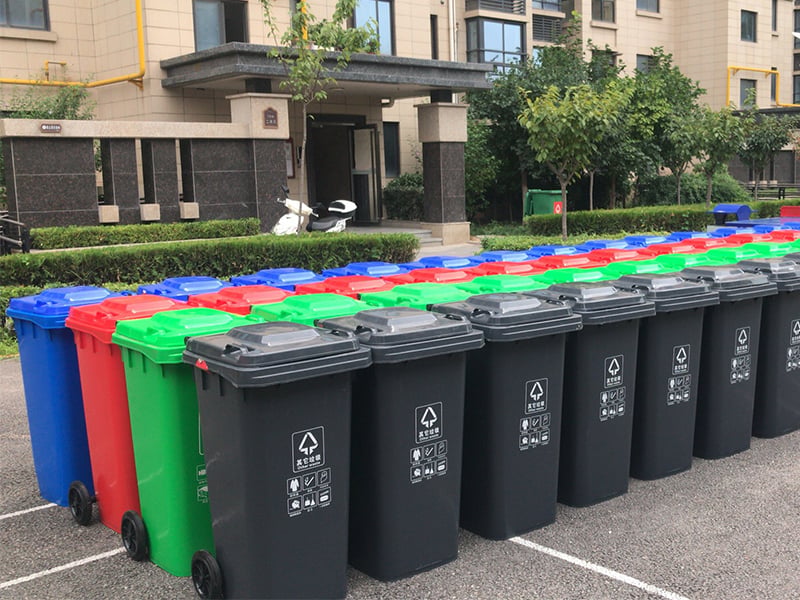 Commercial waste bins in a sorting station with colour-coded lids.jpg