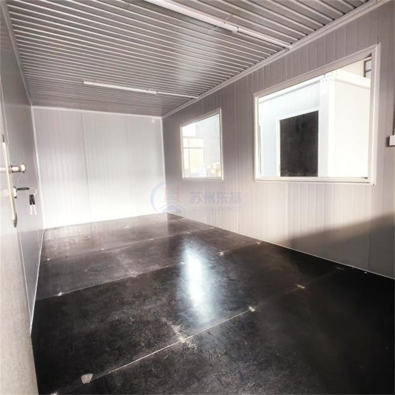 Interior view of modular home showing wall panels, black flooring, and window layout.jpg