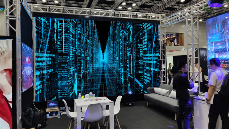 High-definition rental LED video wall mounted on a truss system at a corporate exhibition booth, displaying vibrant 3D digital graphics.