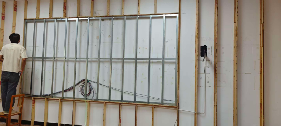 Custom steel framework for indoor LED video wall installation with laser level alignment