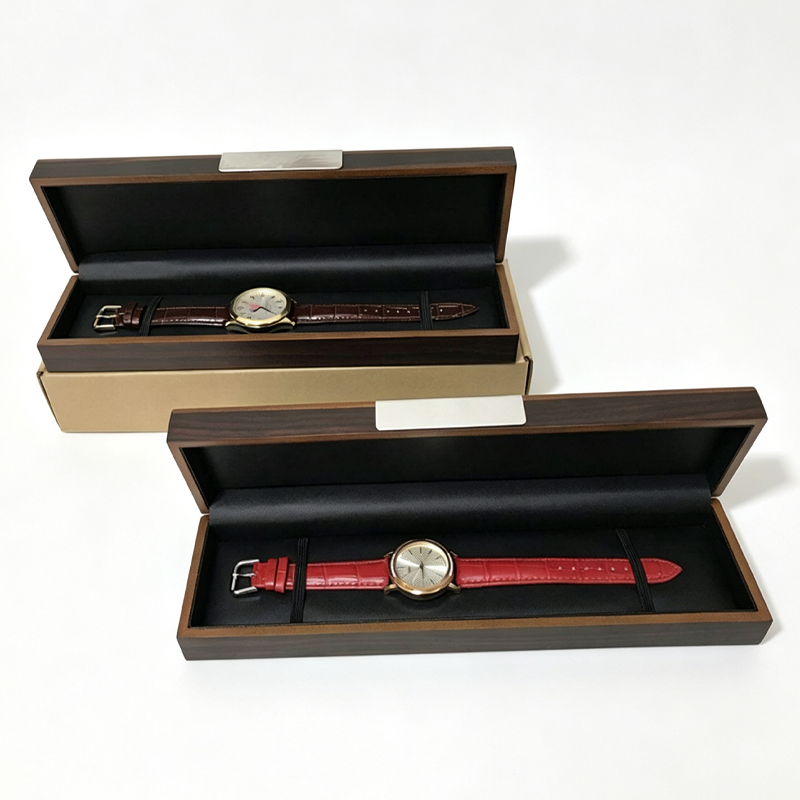 Two open wooden watch boxes side by side, one holding a brown strap watch and one a red strap watch.jpg
