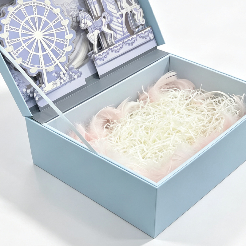 Close-up of the open box showing the pop-up liner and a tray filled with shredded paper and pink feathers.jpg