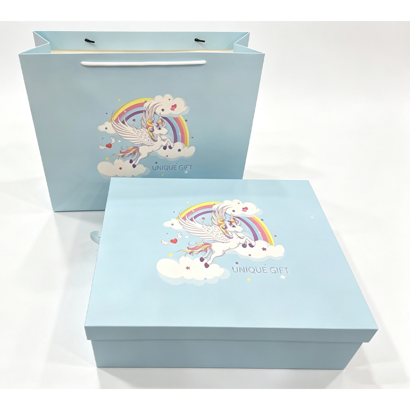 Closed light blue gift box and matching paper bag printed with a rainbow and unicorn illustration.jpg