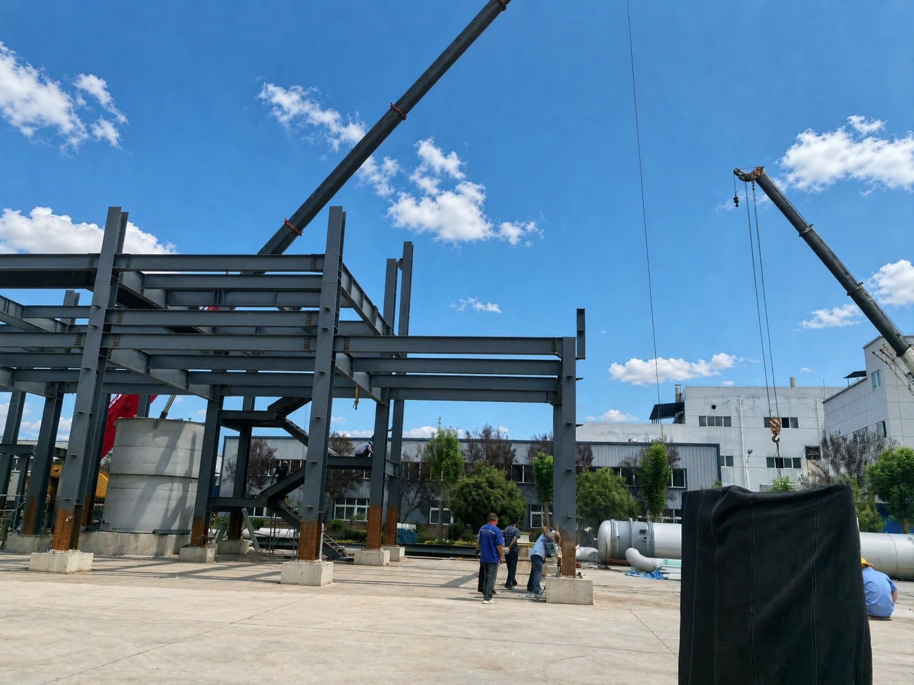 Wide shot of the chemical plant construction site showing the steel frame and ground-level equipment layout