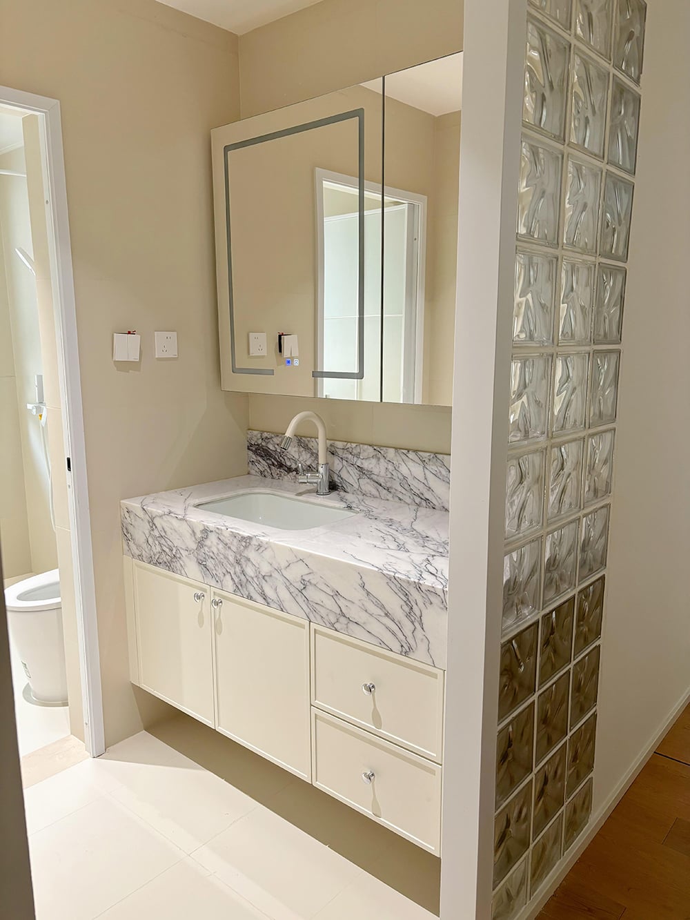 Elegante Mobile Lavabo Beige con Piano di Appoggio a Motivo Marmorizzato, Armadietto con Specchio Illuminato a LED e Design Classico per un Bagno di Lusso