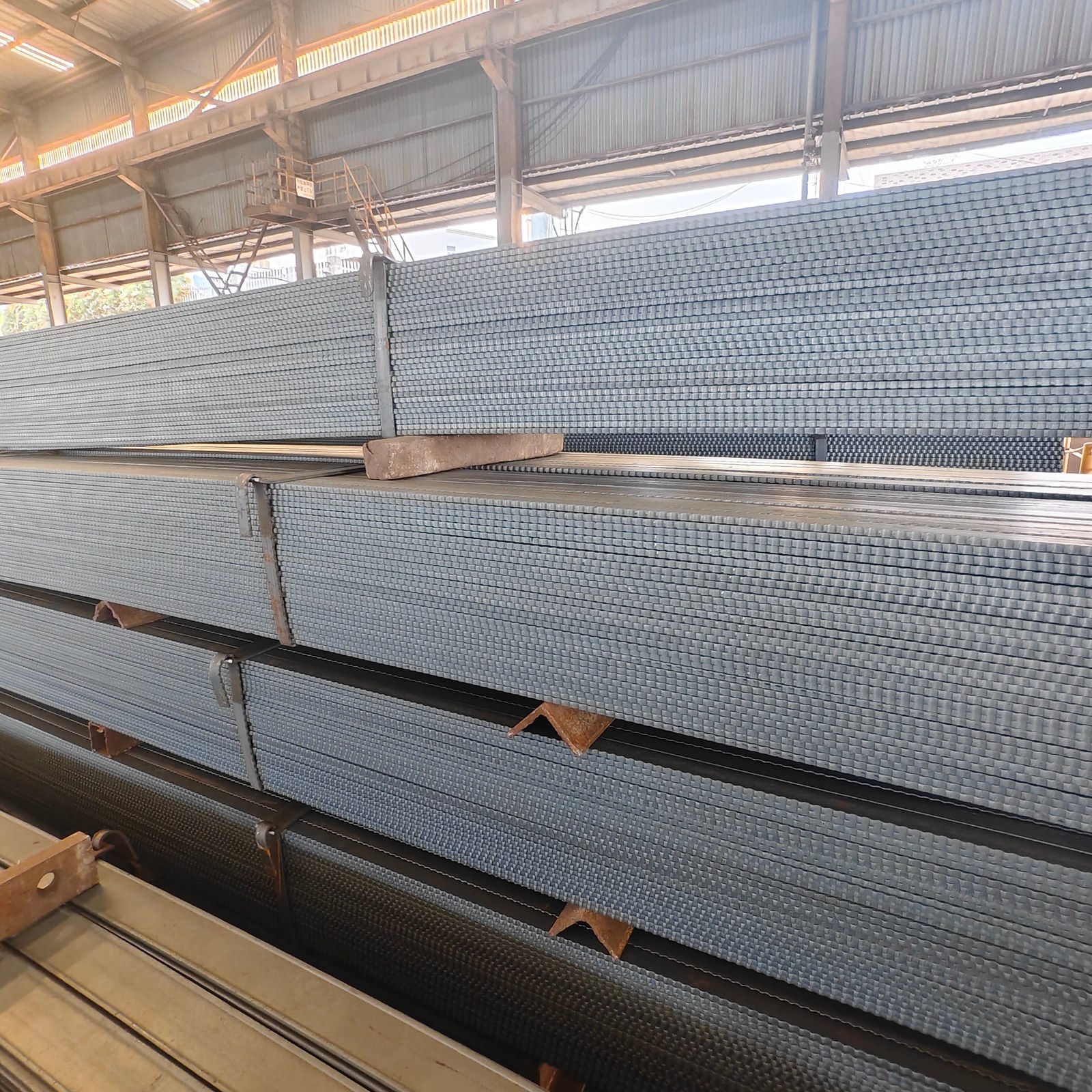 Flat steel stock stacked in the NISCO Sunda workshop
