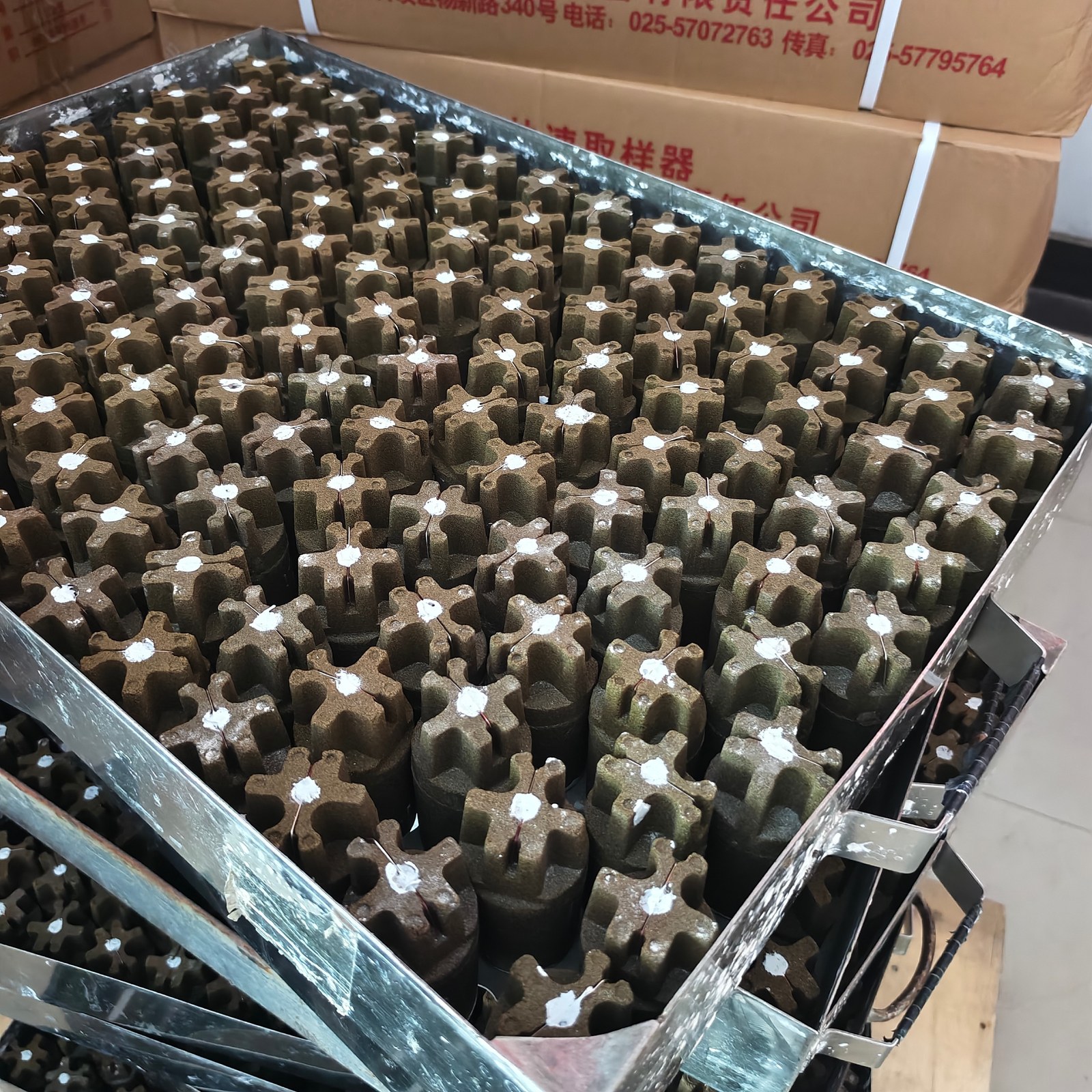 Industrial sensing components arranged in metal trays on the Xinqiyuan line