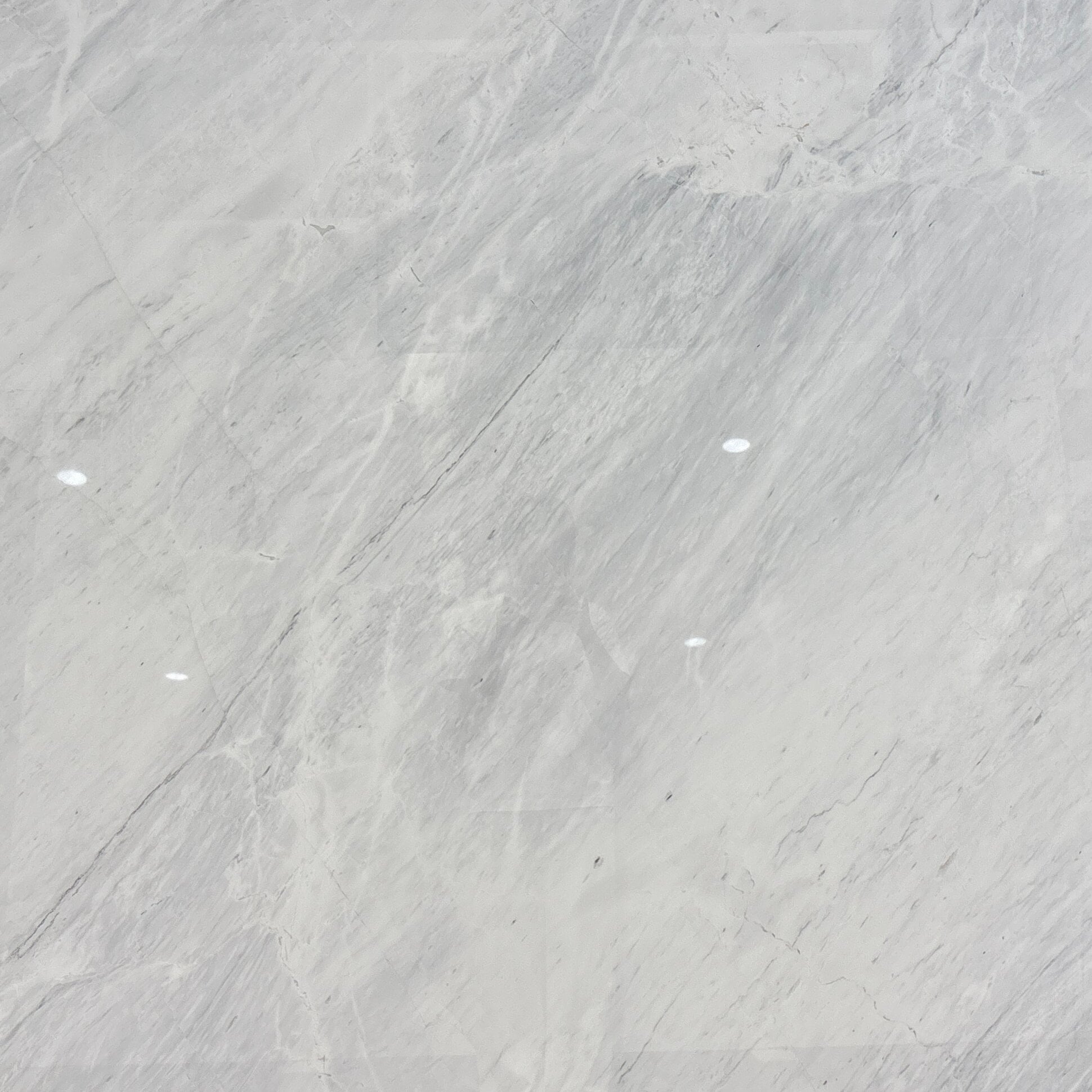 How can you differentiate between white marble and white quartzite