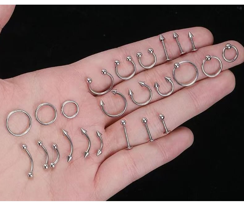 Hand holding stainless steel piercing jewelry collection.jpg