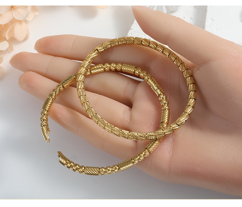 Hand holding gold bangle bracelets, product detail.jpg
