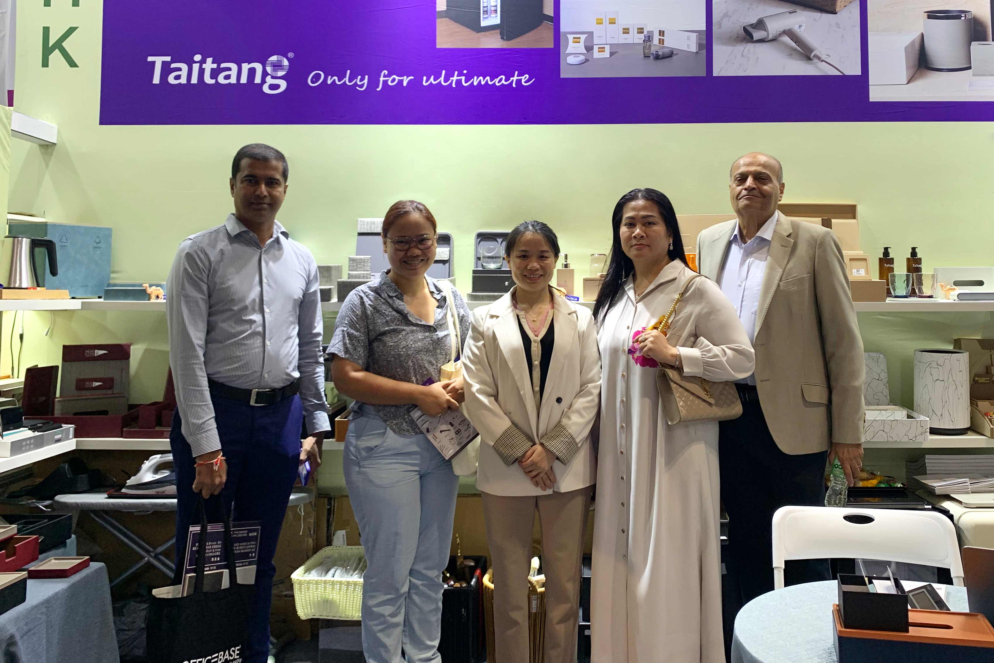 A group photo of international clients and the TAITANG team at a trade show, reflecting successful partnership and global brand trust.