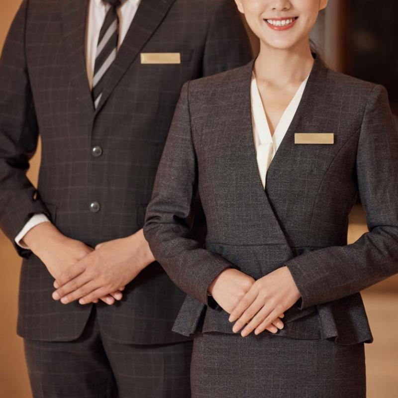 Professional hotel front desk staff in sharp uniforms ready to welcome guests on opening day.jpg