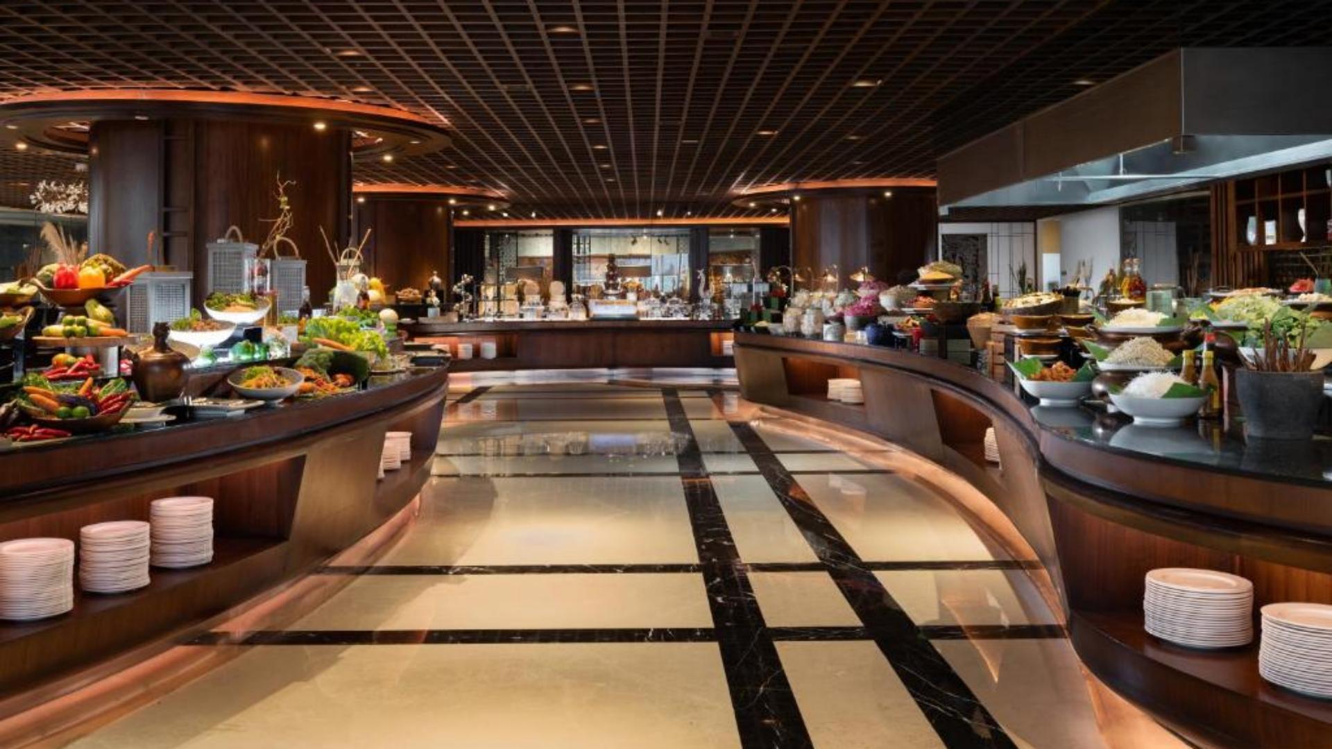 Spacious 5-star hotel buffet counter setup featuring warm lighting and food display stations.jpg