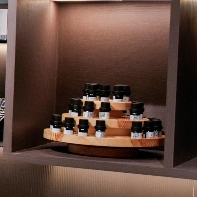 Taitang commercial hotel fragrance essential oil bottles on a tiered wooden display stand for ambient scenting.JPG