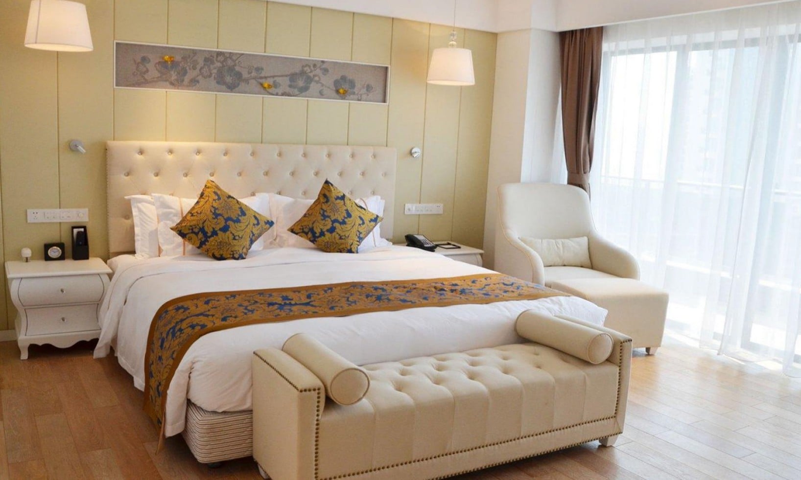 An interior view of a luxury guest room at Wyndham Garden Hainan Lingshui, featuring complete room furnishings and textiles provided by Taitang, showcasing Taitang's expertise as a bed linen manufacturer and hotel room supplies provider for premium resort destinations.