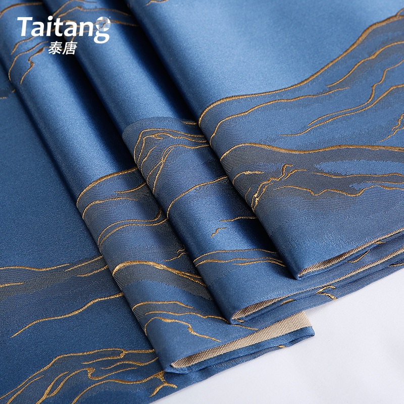 Close-up of Taitang premium blue fabric with intricate gold wave embroidery, designed for hotel bed runners and decor.jpg