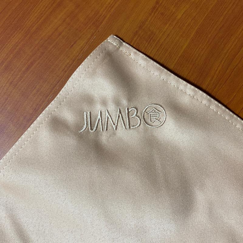 Champagne cloth napkin corner featuring subtle custom embroidered JUMBO logo for fine dining service.JPG