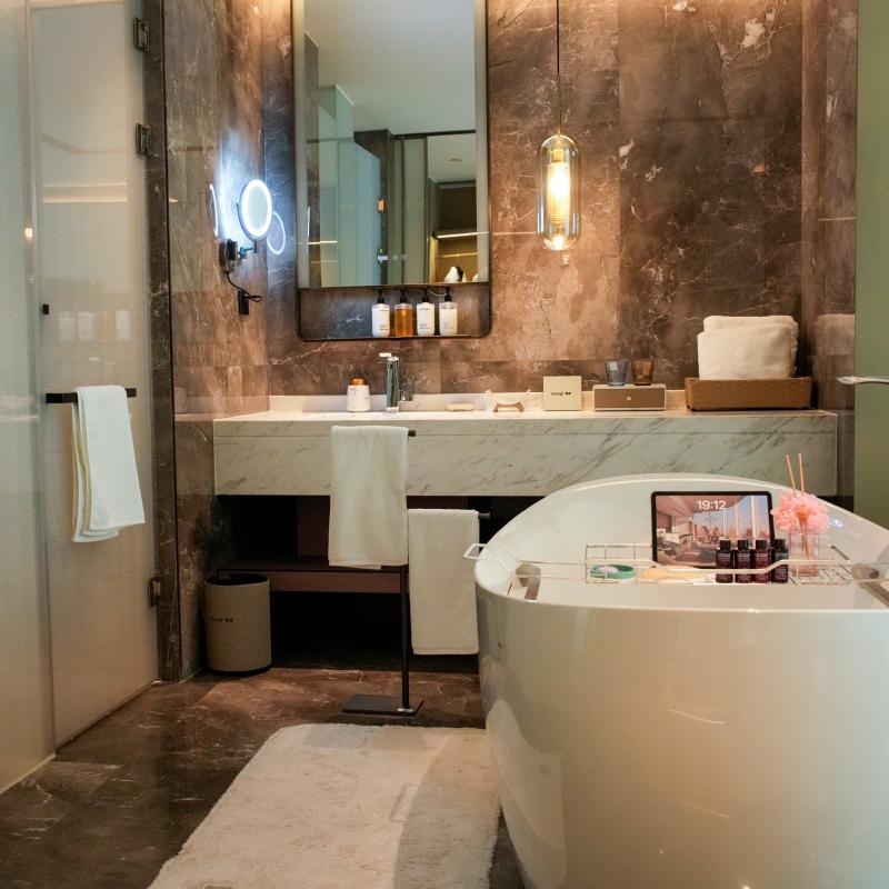 Plush white non-slip hotel bath mat by Taitang placed beside a freestanding soaking tub in a 5-star luxury hotel bathroom.JPG