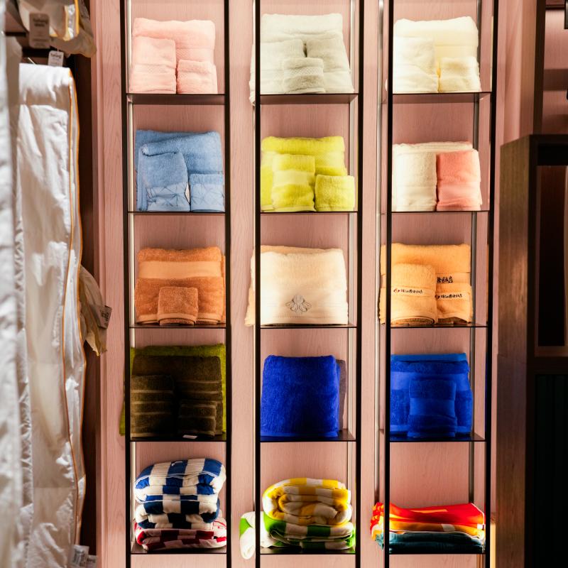 Wholesale colorful resort pool and spa bath towels neatly displayed on showroom shelving by Taitang hotel linen supplier.JPG