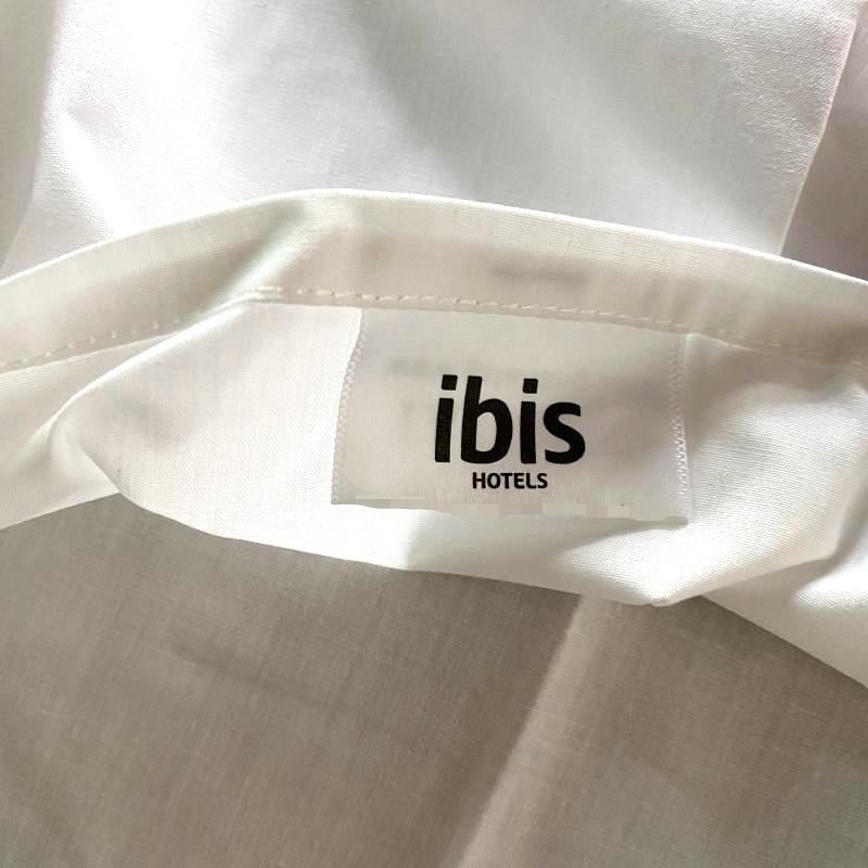 White combed cotton hotel pillowcase showing custom woven brand label reading ibis HOTELS.JPG