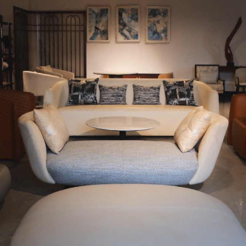 A contemporary hotel sofa and coffee table pairing with minimalist lines and plush textures in a clean showroom setting, exemplifying modern luxury.png