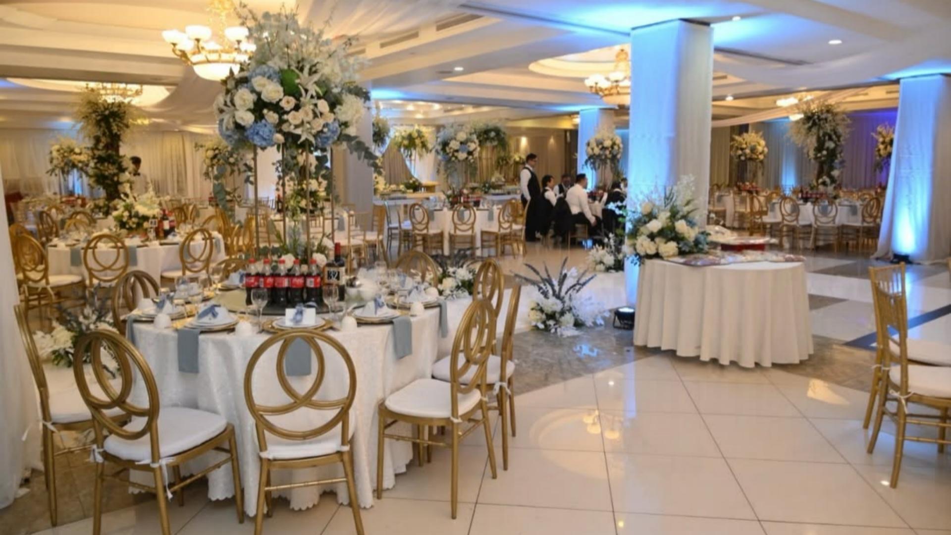 Elegantly decorated wedding banquet hall at Sunly Restaurant featuring round dining tables, white tablecloths, and gold event chairs.jpg