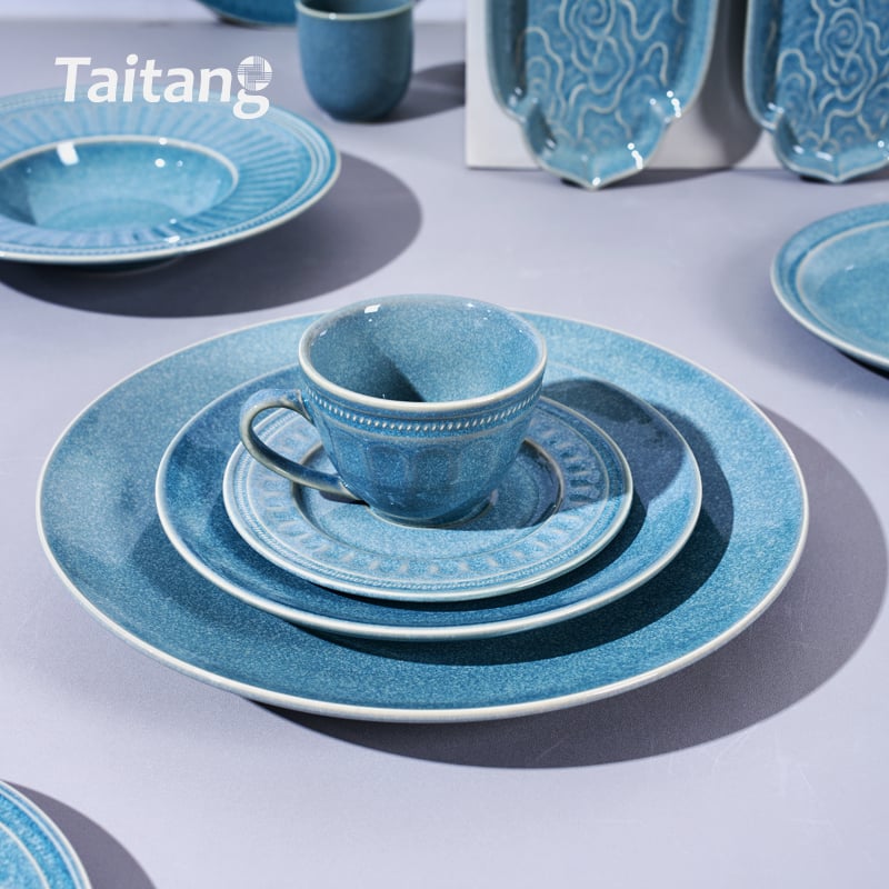 2. Taitang commercial blue ceramic coffee cup with matching saucer resting on stacked dinner plates.jpg
