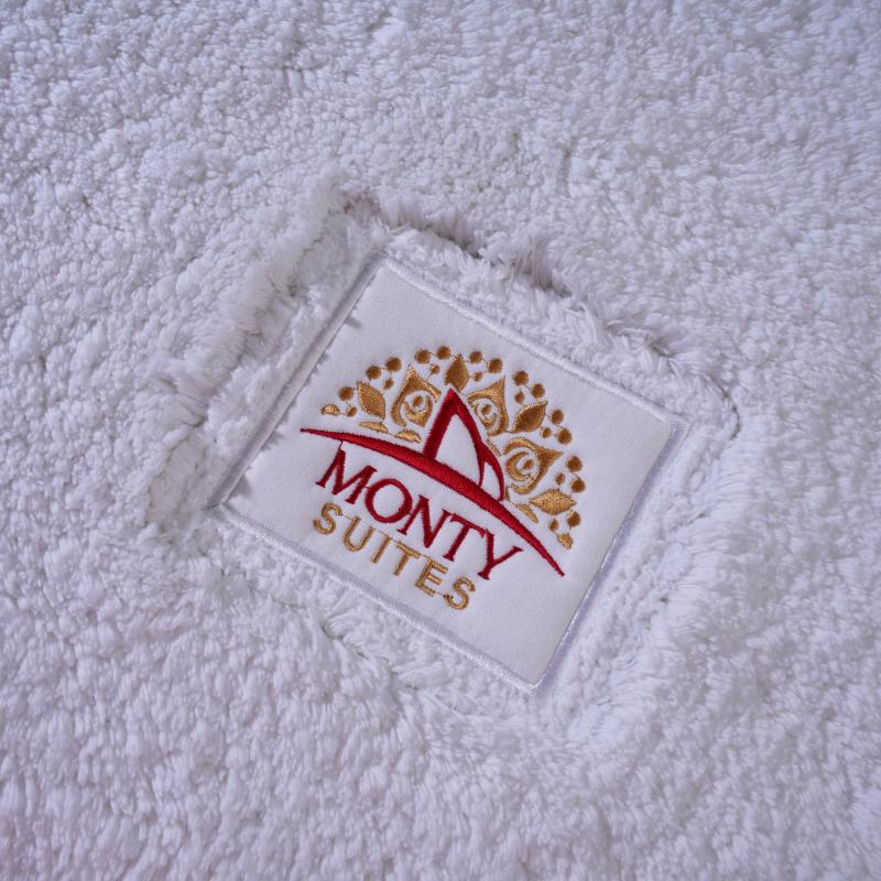 Taitang custom luxury white plush bath mat with gold embroidered logo for Monty Suites.jpg
