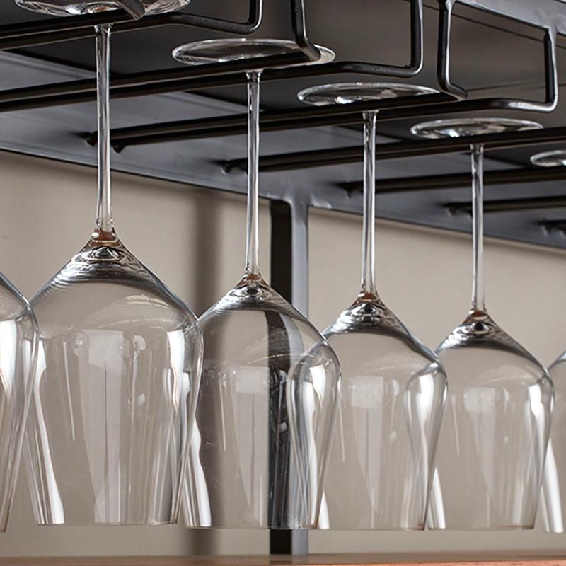 Clean crystal wine glasses stored inverted on an overhead hanging stemware rack in a hotel bar.jpg
