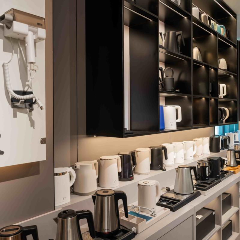 Display shelf featuring Taitang commercial hotel room appliances, including stainless steel electric kettles, hair dryers, and guest room electronics.jpg