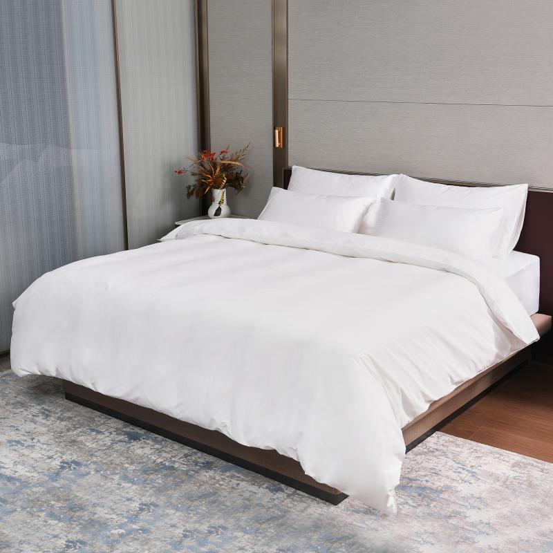 A fully dressed luxury hotel king bed featuring Taitang crisp white commercial bedding sheets and duvet cover.jpg