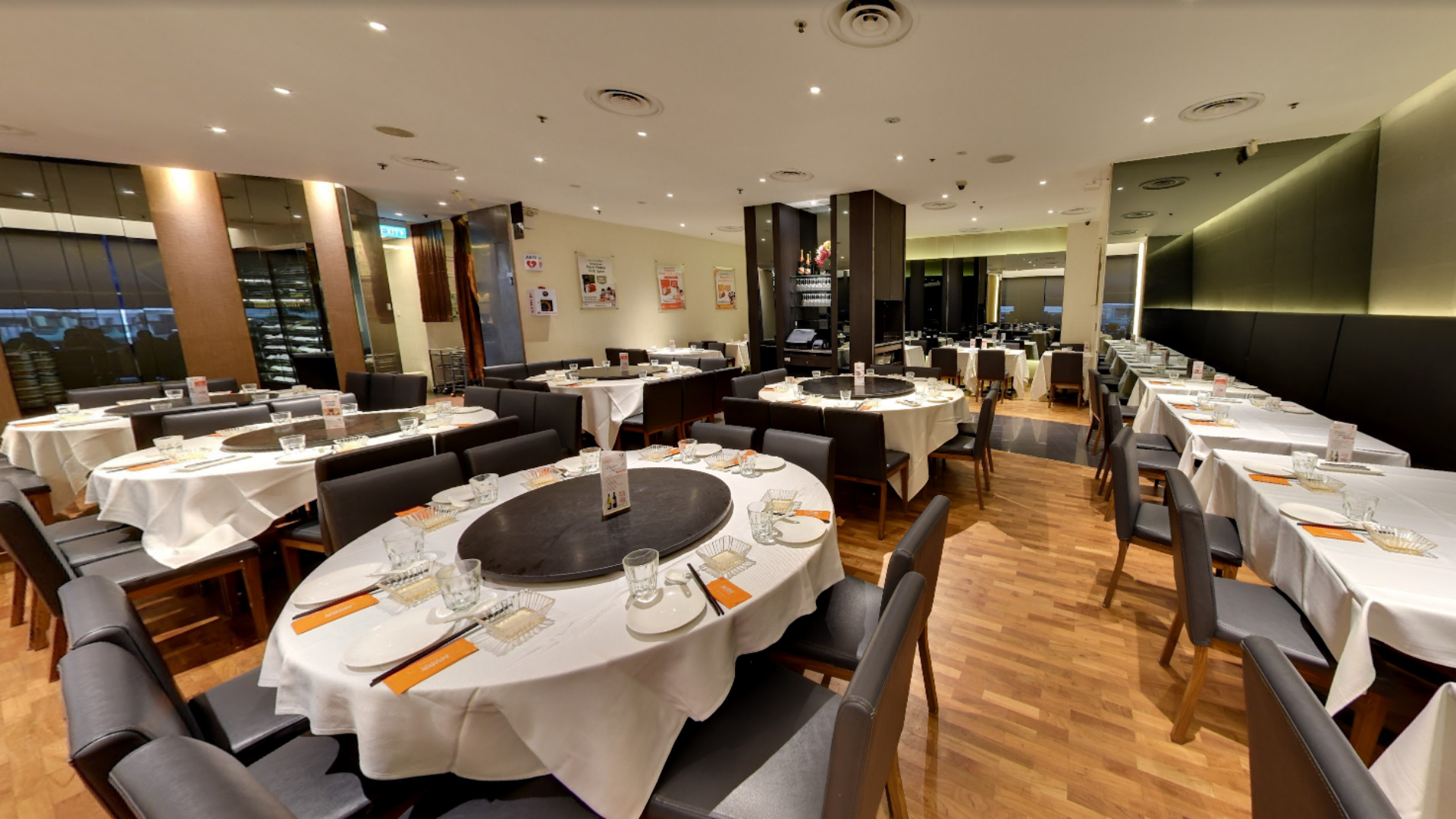 Modern JUMBO Seafood dining hall interior set up with round dining tables draped in crisp white tablecloths.png