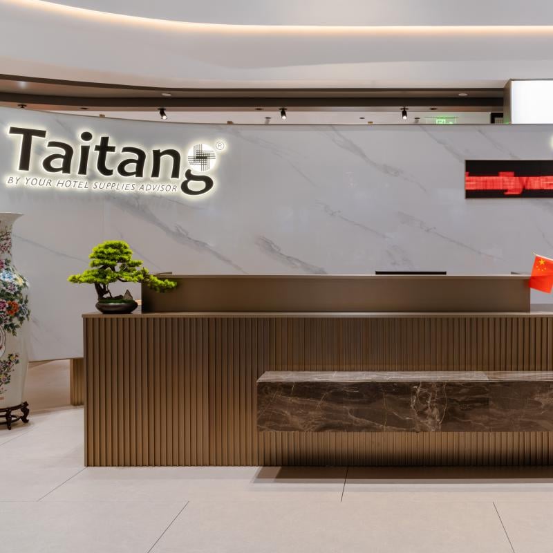 Taitang corporate office reception lobby featuring illuminated brand logo and modern welcoming interior for hospitality clients.jpg