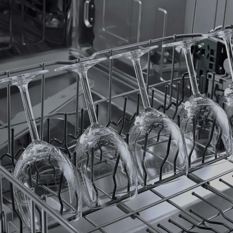 Crystal stemware loaded inverted in a commercial dishwasher rack for safe high-temperature washing.webp