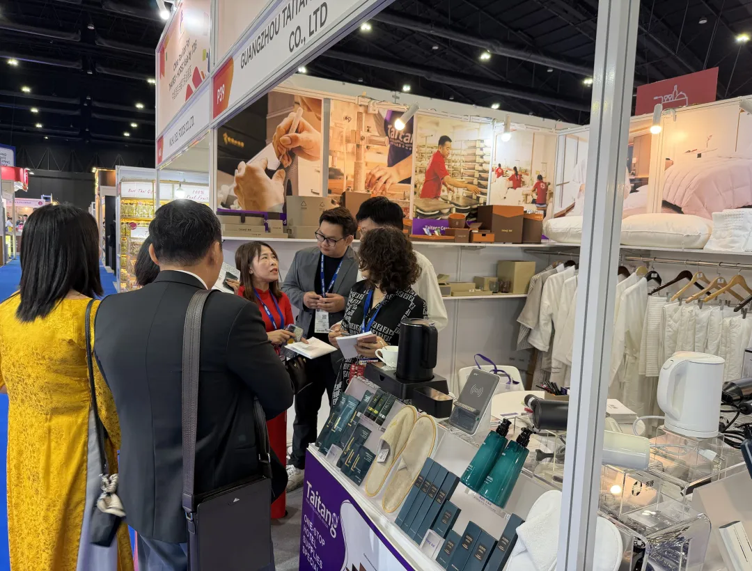 Busy scene at Taitang’s THAIFEX-HOREC booth showing a wide range of hotel room supplies including slippers, toiletries, and kettles.