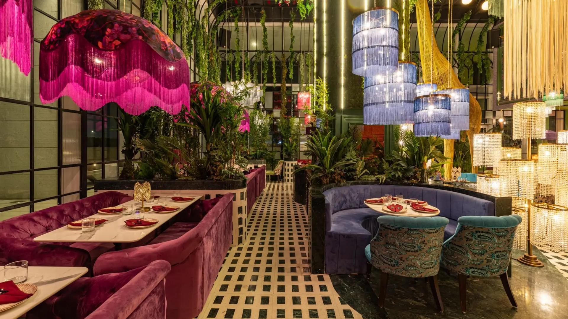 Vibrant experiential dining room with plush booth seating, decorative lighting, and luxury interior styling.webp