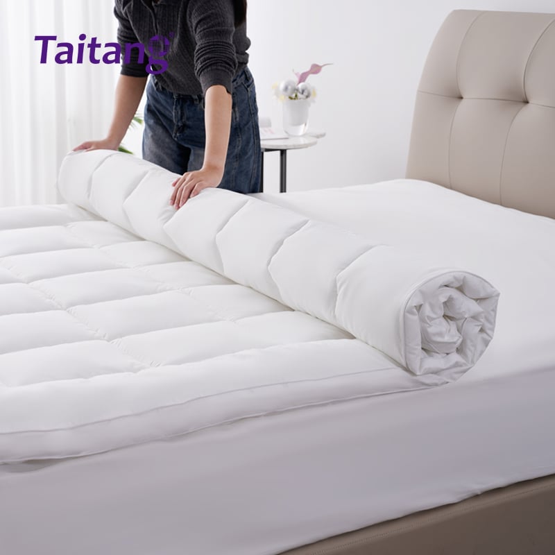 3. Housekeeping staff unrolling a Taitang luxury suite mattress topper onto a guest bed..jpg