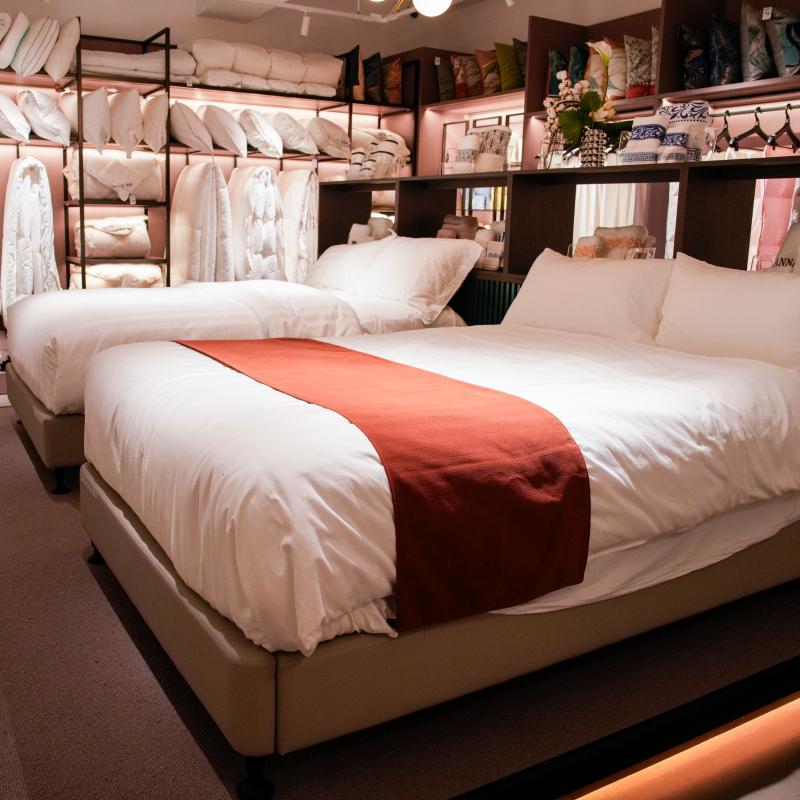 Luxury hotel suite bed setting with pristine white Taitang duvets, decorative bed runners, and supportive hotel pillows.JPG