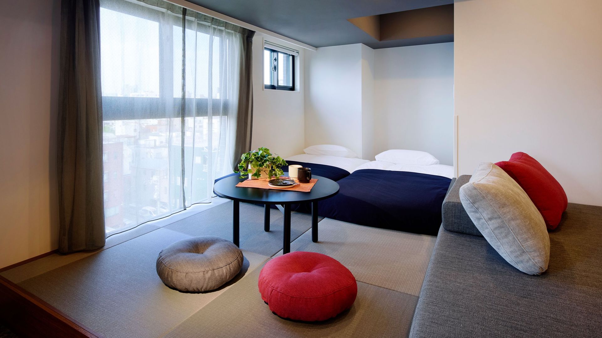 Japanese-inspired hotel guestroom interior with tatami cushion seating area and comfortable twin beds.jpg