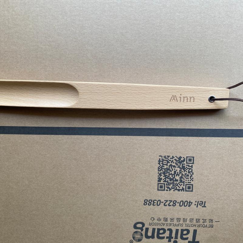 Custom wooden hotel shoehorn with laser-engraved logo displayed on Taitang packaging.JPG