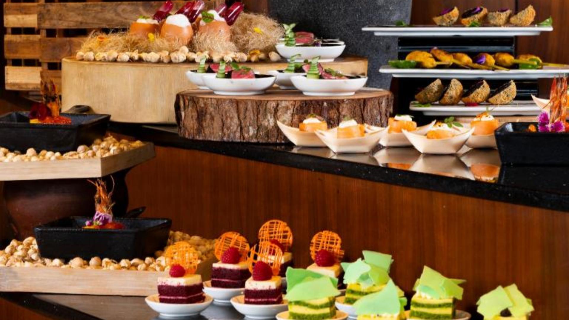 Luxury hotel breakfast buffet dessert station with rustic wood risers and gourmet pastries.jpg