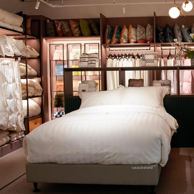 Luxury hotel room bed set with crisp white commercial bedding, duvet, and pillows in Taitang hotel supply showroom.JPG