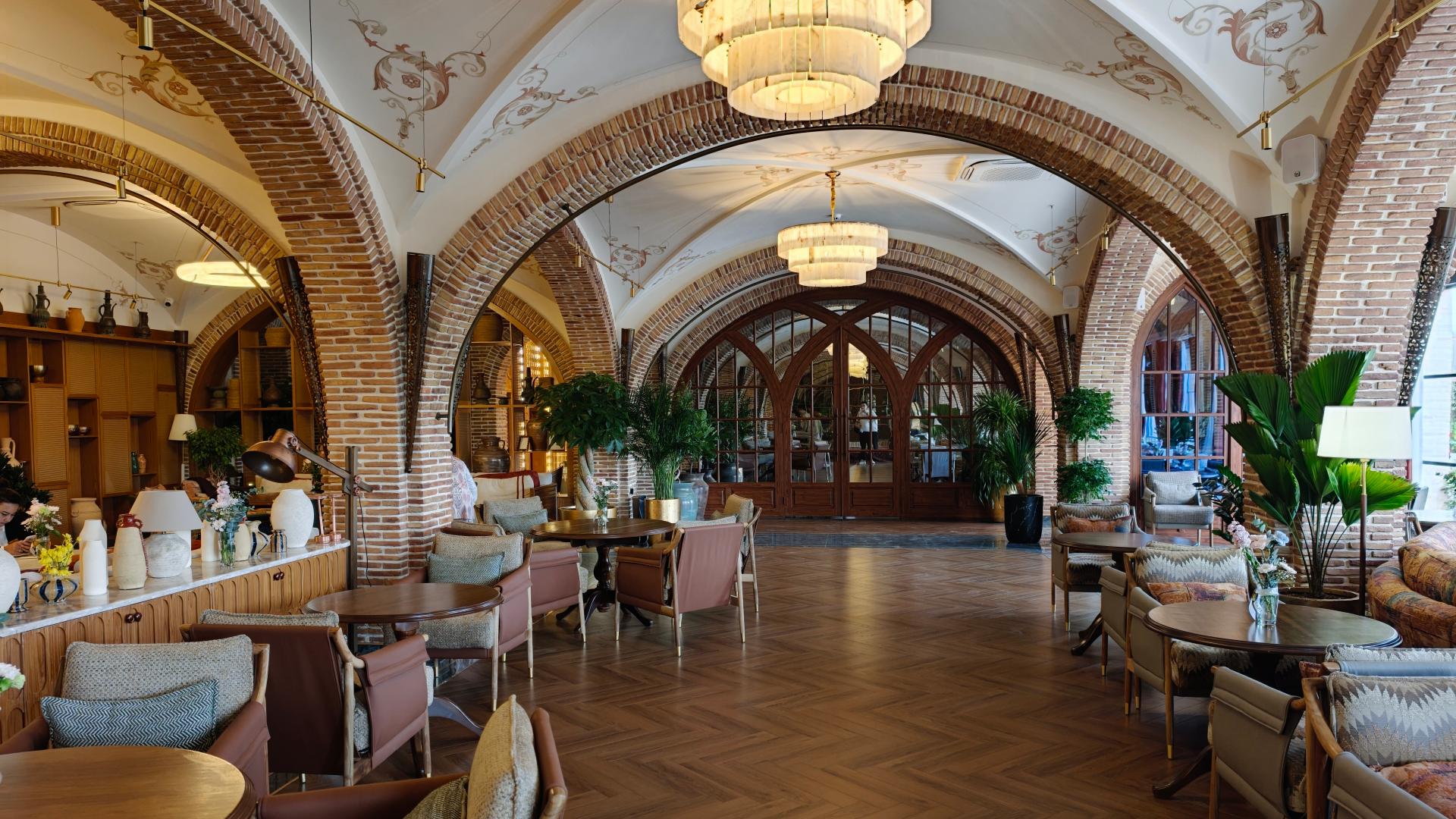 Spacious resort dining hall featuring traditional arched ceilings, chandelier lighting, and set tables.jpg